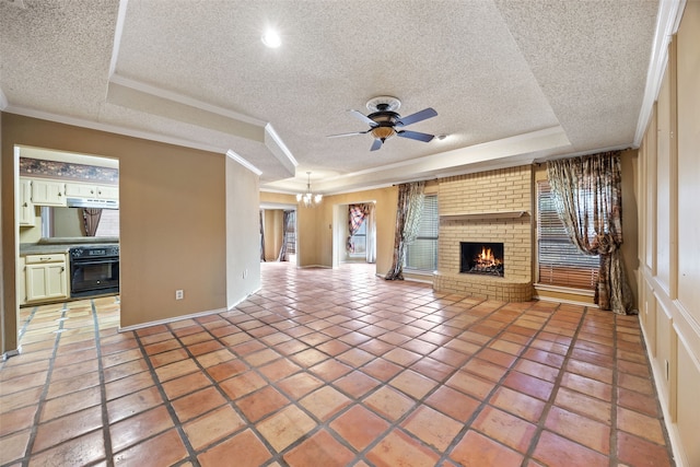 unfurnished living room with a tray ceiling, a brick fireplace, light tile patterned flooring, and ceiling fan with notable chandelier