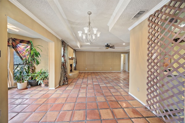 interior space featuring visible vents, crown molding, a raised ceiling, and a brick fireplace