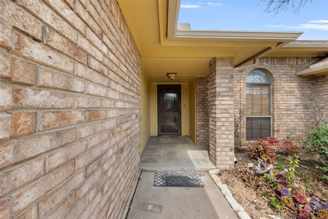 view of exterior entry with brick siding