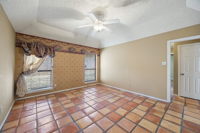 tiled empty room with baseboards, a textured ceiling, and ceiling fan