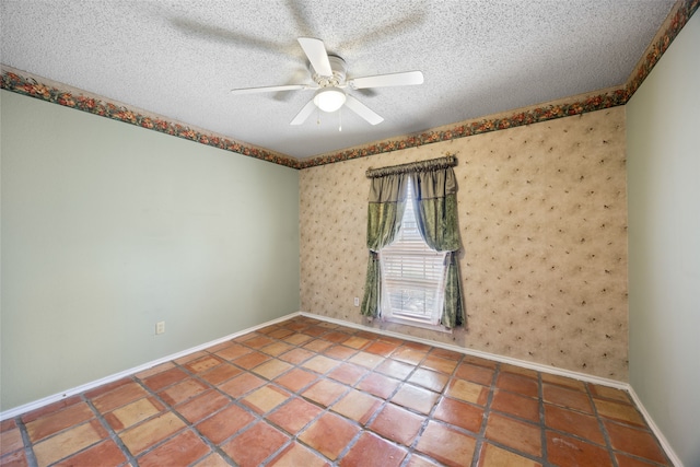 spare room with wallpapered walls, a ceiling fan, baseboards, and a textured ceiling