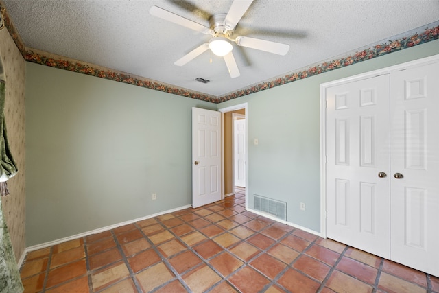 unfurnished bedroom with visible vents, a textured ceiling, and a ceiling fan