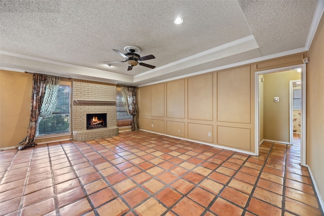 unfurnished living room featuring crown molding, light tile patterned floors, a textured ceiling, a raised ceiling, and a ceiling fan