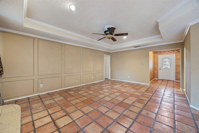 unfurnished living room with a decorative wall, ceiling fan, and a tray ceiling
