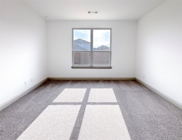 carpeted empty room featuring visible vents and baseboards