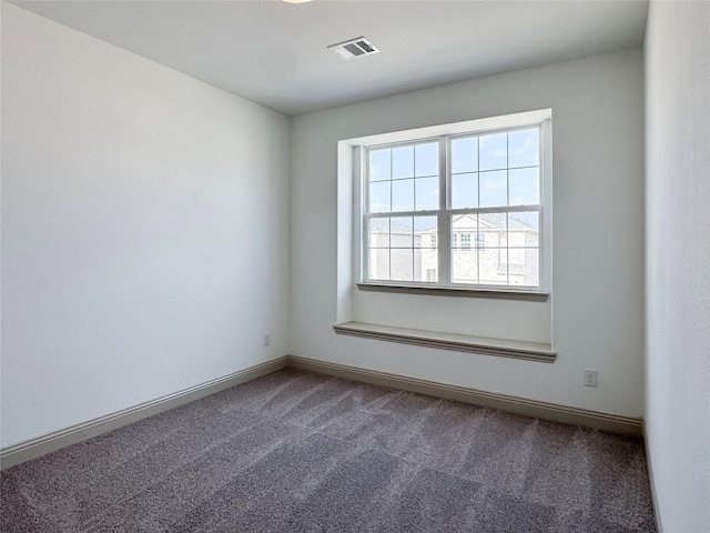 carpeted empty room with visible vents and baseboards