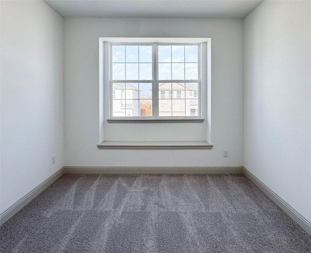 carpeted spare room featuring baseboards