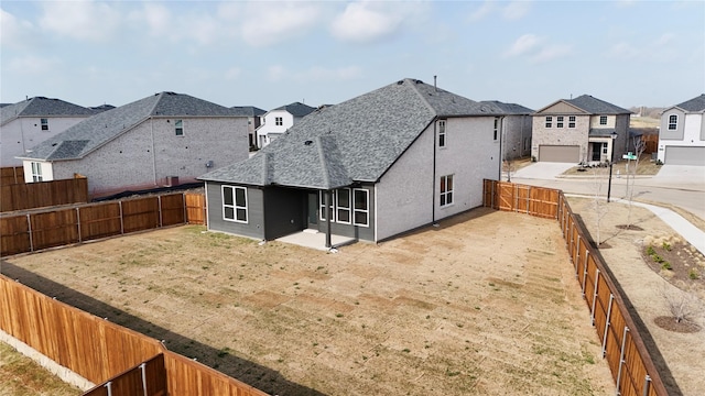 rear view of house with a residential view, a shingled roof, and a fenced backyard