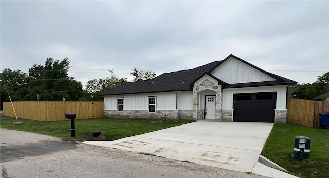 ranch-style home with an attached garage, stone siding, a front lawn, and concrete driveway