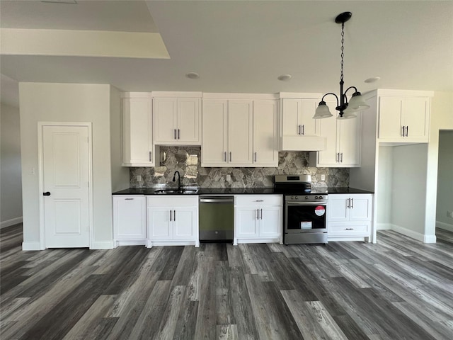 kitchen with white cabinets, dark countertops, a sink, baseboards, and appliances with stainless steel finishes