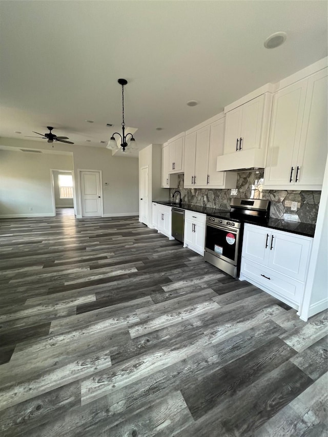 kitchen with white cabinets, decorative backsplash, dark countertops, and stainless steel appliances