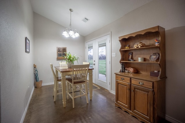 dining space with visible vents, a notable chandelier, finished concrete flooring, baseboards, and vaulted ceiling