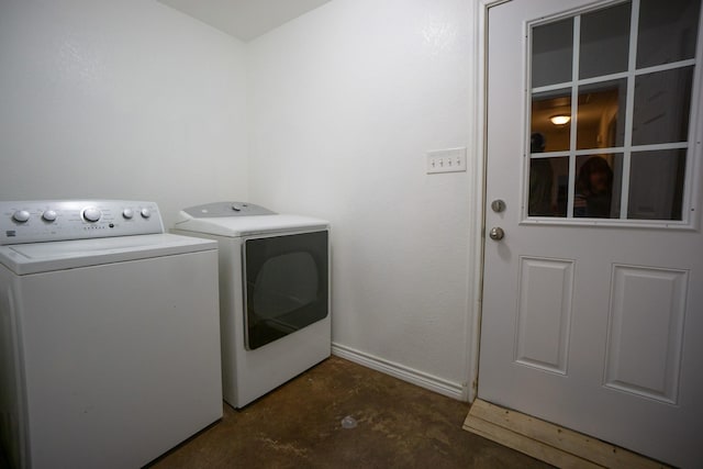 laundry room with laundry area, washing machine and dryer, and baseboards