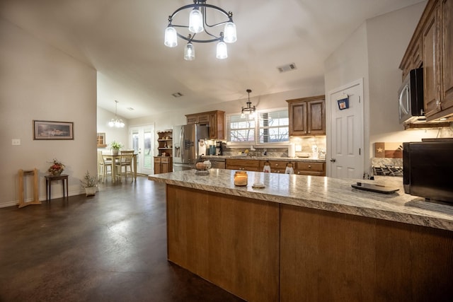 kitchen featuring visible vents, a notable chandelier, appliances with stainless steel finishes, a peninsula, and vaulted ceiling