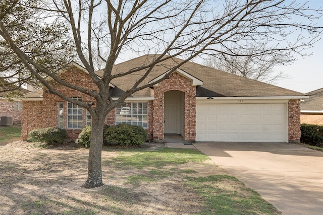 ranch-style home featuring central air condition unit, driveway, a shingled roof, a garage, and brick siding