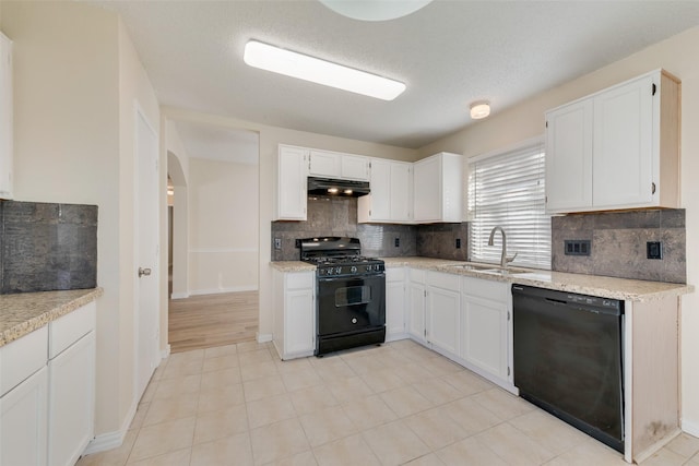 kitchen featuring under cabinet range hood, white cabinetry, black appliances, and a sink