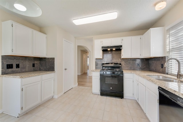 kitchen featuring arched walkways, a sink, black appliances, white cabinets, and under cabinet range hood