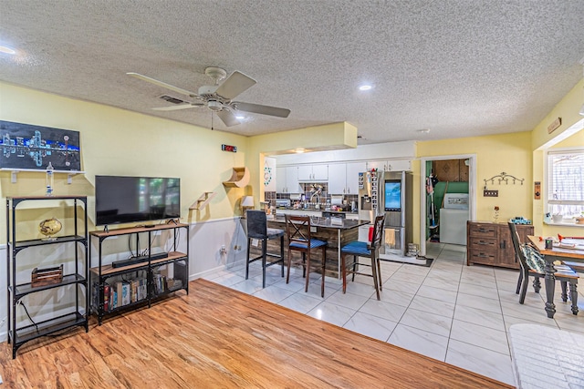 3805 Hastings Dr, Arlington, TX 76013 - dining area with washer / dryer, ceiling fan, a textured ceiling, and light tile patterned floors