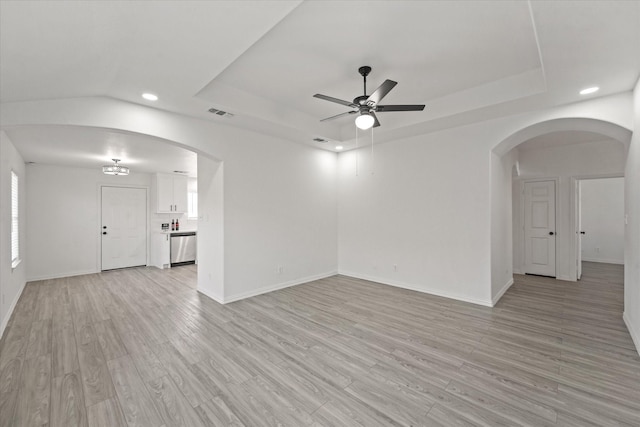 14514 Seagoville Rd, Dallas, TX 75253 - unfurnished living room with recessed lighting, a ceiling fan, light wood-style floors, a tray ceiling, and arched walkways