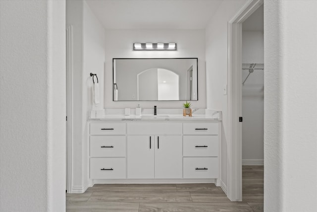 14514 Seagoville Rd, Dallas, TX 75253 - full bath featuring baseboards, a walk in closet, vanity, and wood finished floors
