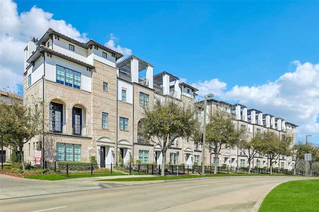 view of building exterior with a residential view and a fenced front yard