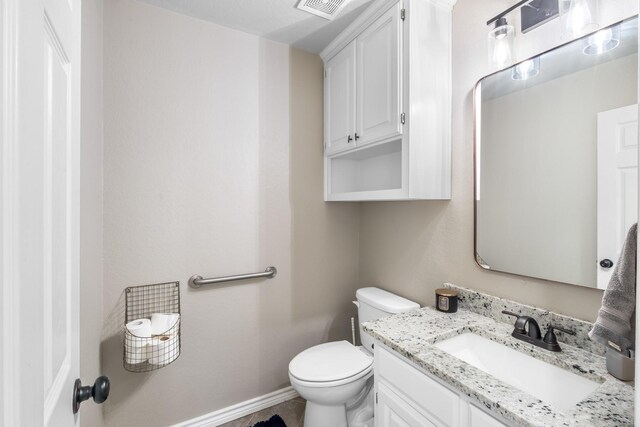 bathroom featuring vanity, toilet, baseboards, and visible vents