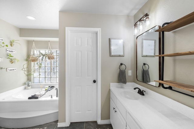 full bath featuring vanity, a garden tub, baseboards, and tile patterned flooring