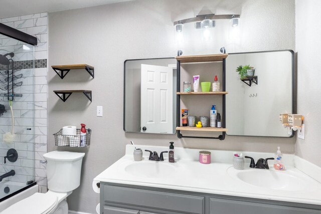 full bathroom with double vanity, toilet, and a sink