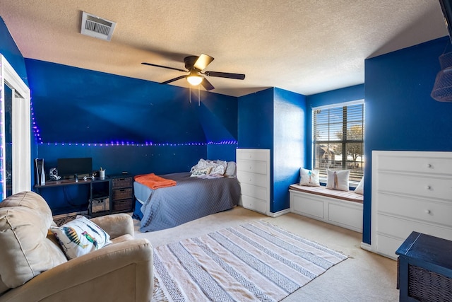 bedroom featuring a ceiling fan, carpet, visible vents, and a textured ceiling