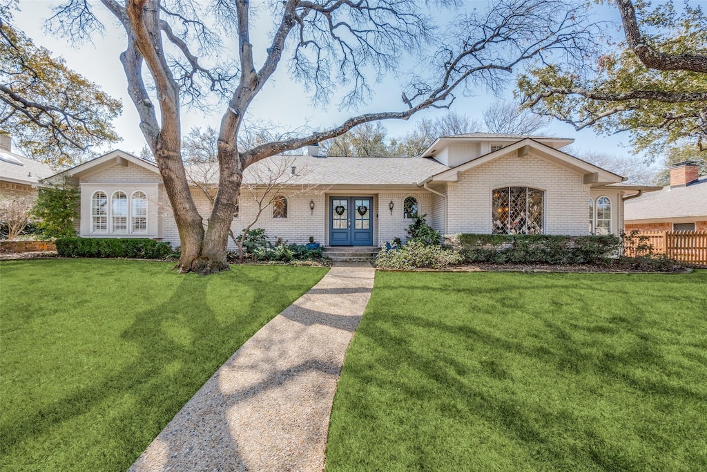 9424 Trail Hill Dr, Dallas, TX 75238 - view of front of home featuring brick siding, french doors, and a front lawn