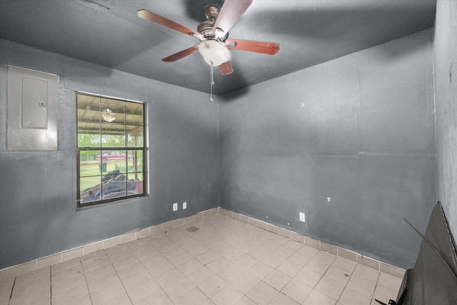 empty room with a ceiling fan, tile patterned flooring, and electric panel