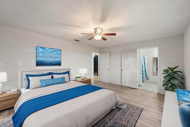 bedroom featuring a ceiling fan, wood finished floors, connected bathroom, baseboards, and visible vents