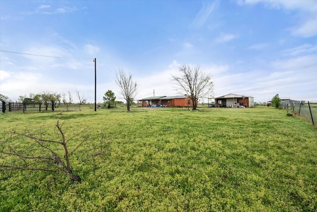 view of yard with fence and a rural view