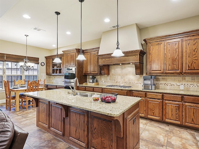 741 Butchart Dr, Prosper, TX 75078 - kitchen with a sink, stainless steel appliances, decorative backsplash, an island with sink, and brown cabinetry