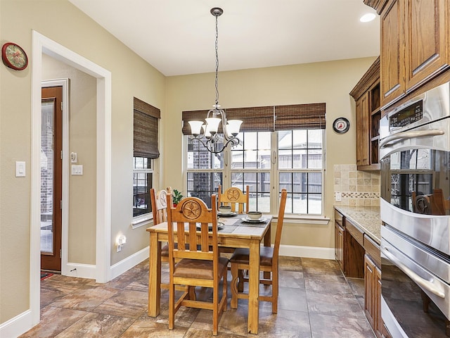 741 Butchart Dr, Prosper, TX 75078 - dining area featuring a chandelier, baseboards, and stone tile floors