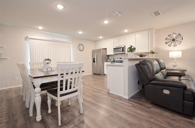 dining room with dark wood-style floors, visible vents, recessed lighting, and baseboards