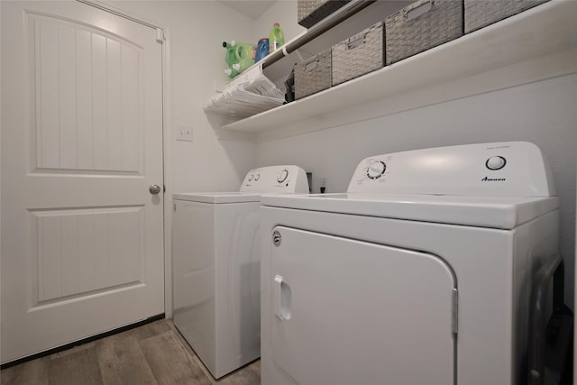 laundry area featuring laundry area, light wood-style flooring, and separate washer and dryer