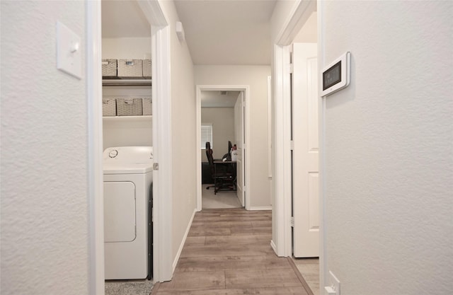 laundry area featuring baseboards, washer / dryer, and light wood-style flooring