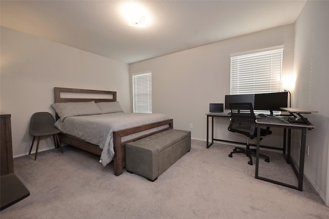 bedroom featuring baseboards and light carpet