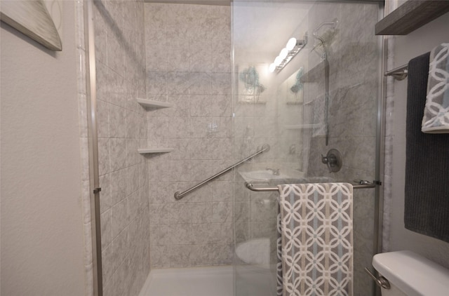 full bath featuring a stall shower and toilet