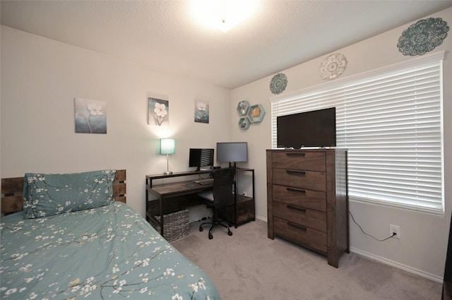 bedroom with a textured ceiling, baseboards, and carpet floors