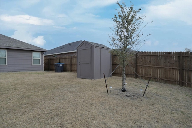 view of yard featuring a fenced backyard, a storage unit, and an outdoor structure