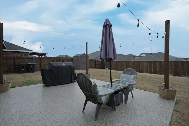 view of patio / terrace featuring a fenced backyard, an outbuilding, a storage shed, and grilling area