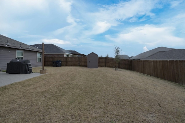 view of yard featuring an outbuilding, a shed, a patio, and a fenced backyard