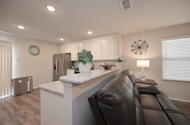 living room featuring visible vents, recessed lighting, baseboards, and wood finished floors