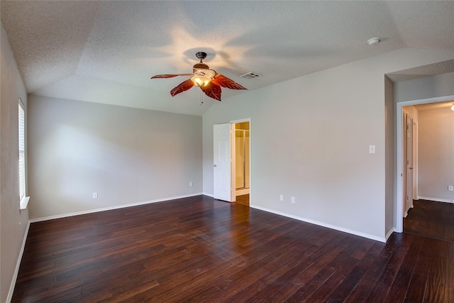 spare room with dark wood finished floors, lofted ceiling, visible vents, and ceiling fan