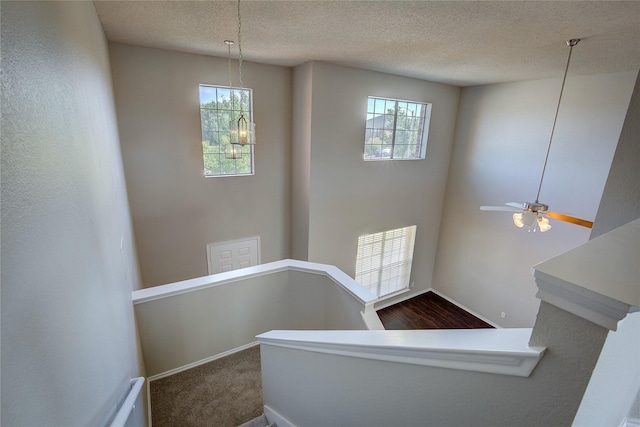 staircase with carpet flooring, a textured ceiling, and a notable chandelier