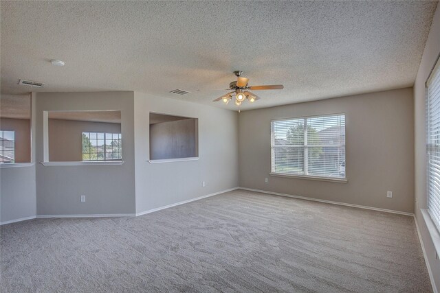 spare room featuring ceiling fan, visible vents, and a wealth of natural light