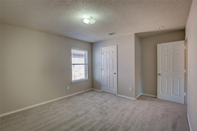 unfurnished bedroom featuring carpet flooring, baseboards, a textured ceiling, visible vents, and a closet