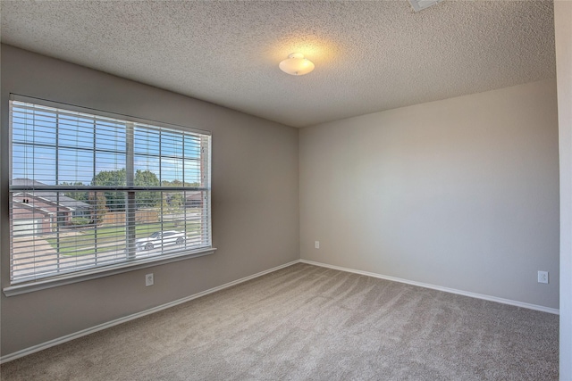 unfurnished room featuring baseboards, carpet floors, and a textured ceiling